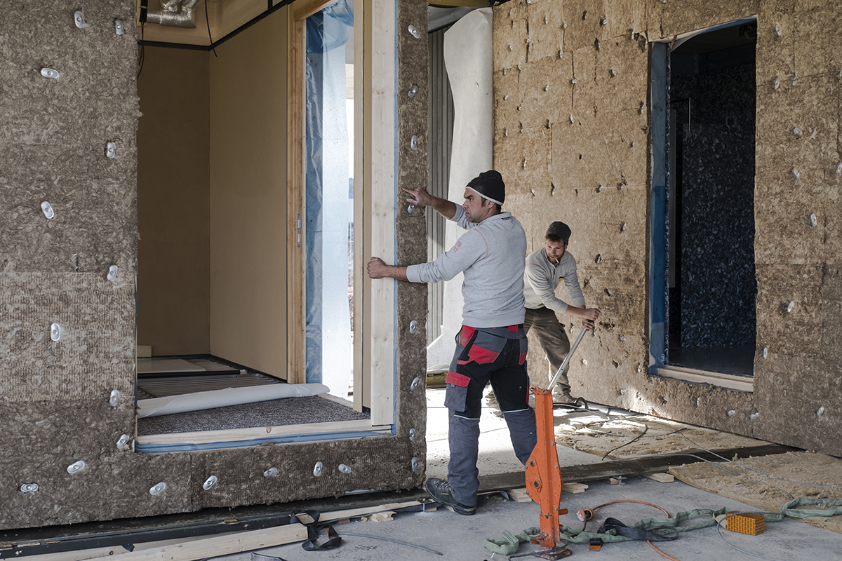 Die vorgefertigten Holzmodule mit Dämmstoffen aus Textilfasern beim Einbau.