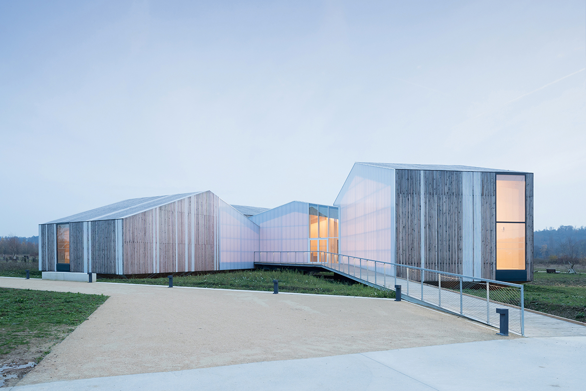 Das Insektenmuseum: mehrere aus Holz gefertigte und horizontal aneinandergefügte abstrakte Hausformen mit Satteldach.