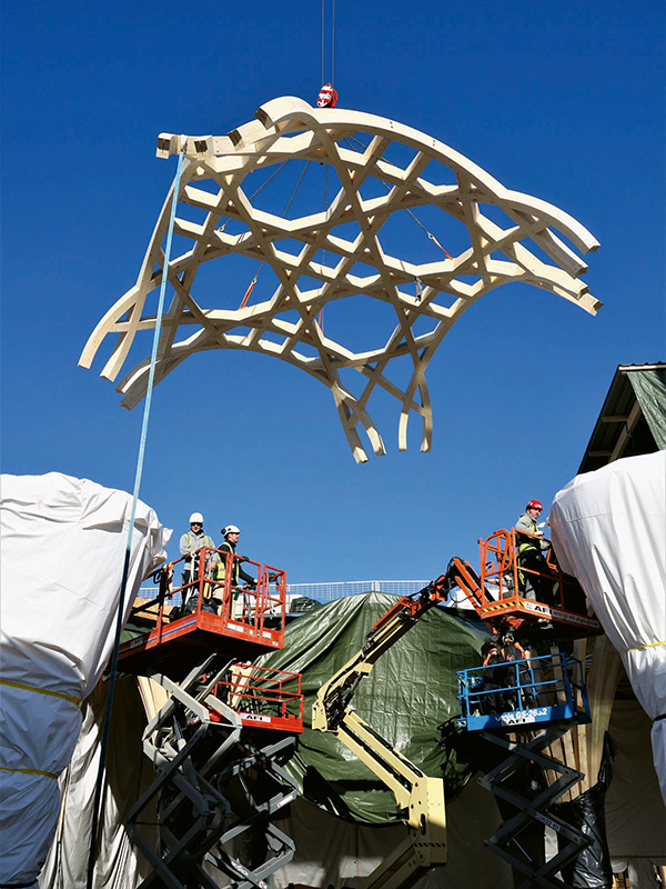 Eines der Dachelemente wird mit einem Kran aufgesetzt.