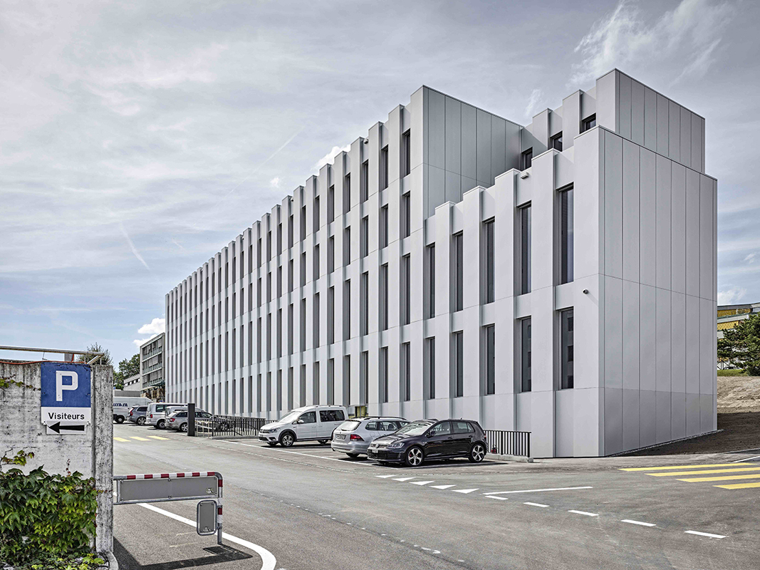 Der viergeschossige Neubau für die Kantonspolizei (MAD 3) in Granges-Paccot FR verrät von aussen nichts von seiner Holzkonstruktion (Architektur: deillon delley architectes sa, Bulle)