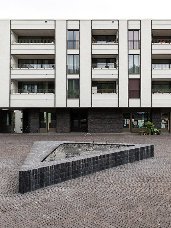 Das neue Zentrum des Gartenstadtquartiers am Friesenberg ist spärlich, mit einem Brunnen und einigen Bäumen, möbliert.