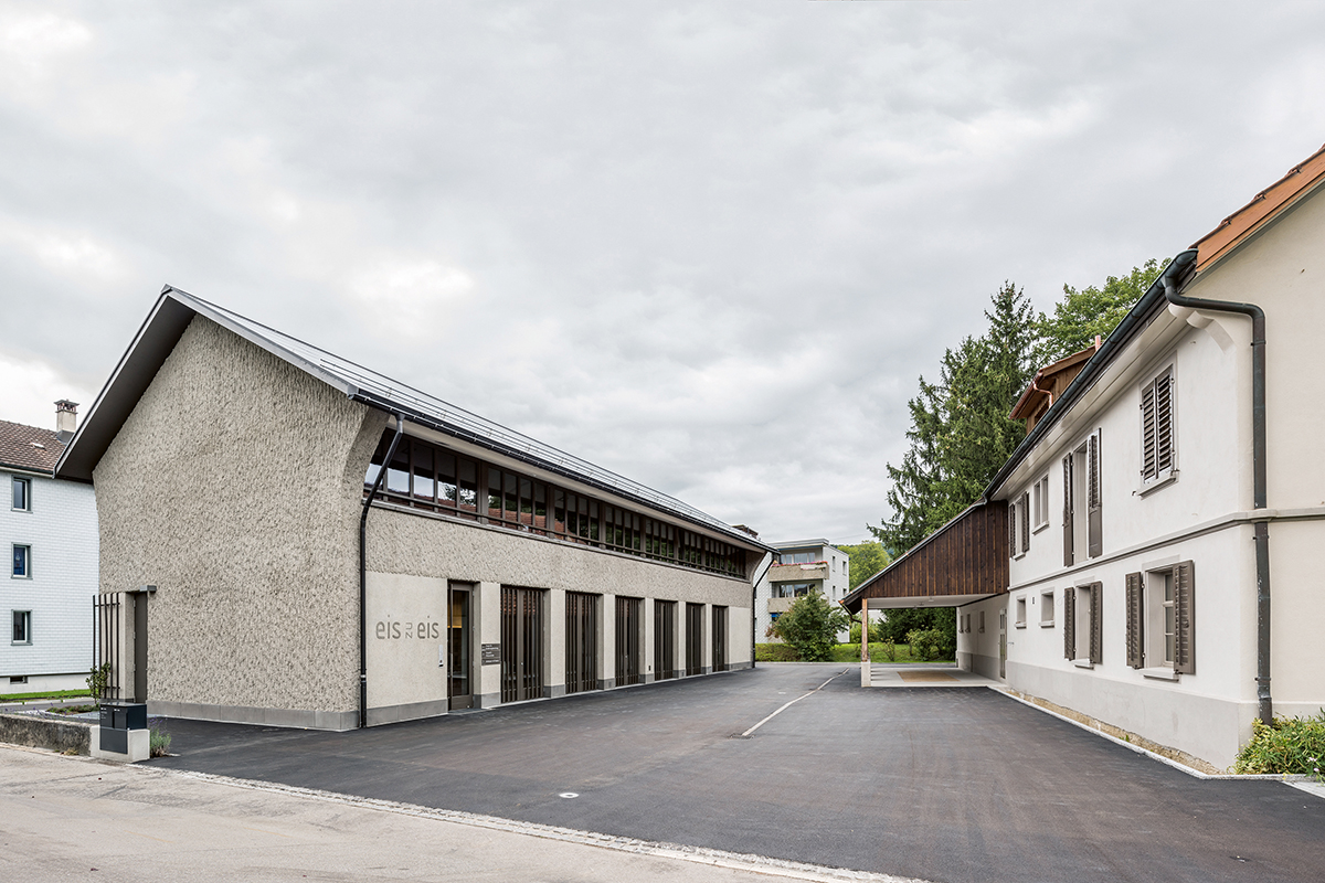 Der Neubau (links) orientiert sich an traditionellen Gebäudeformen und wurde in Anlehnung an den Altbau formuliert. Der Schopf steht – anders als der Vorgänger – parallel zur Grundstücksgrenze. So entsteht zwischen den beiden Häusern ein trapezförmiger Platz.