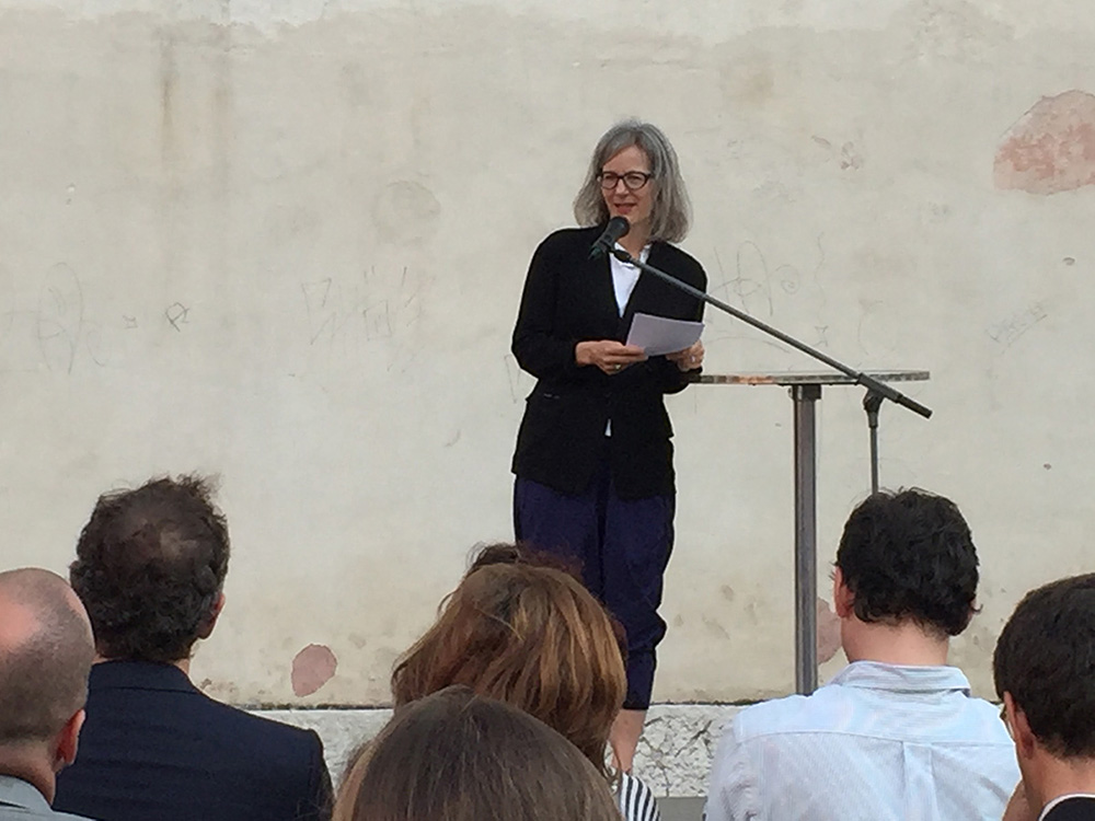 Marianne Burki, Pro Helvetia, bei der Begrüssung auf einem Sportplatz unter freiem Himmel.