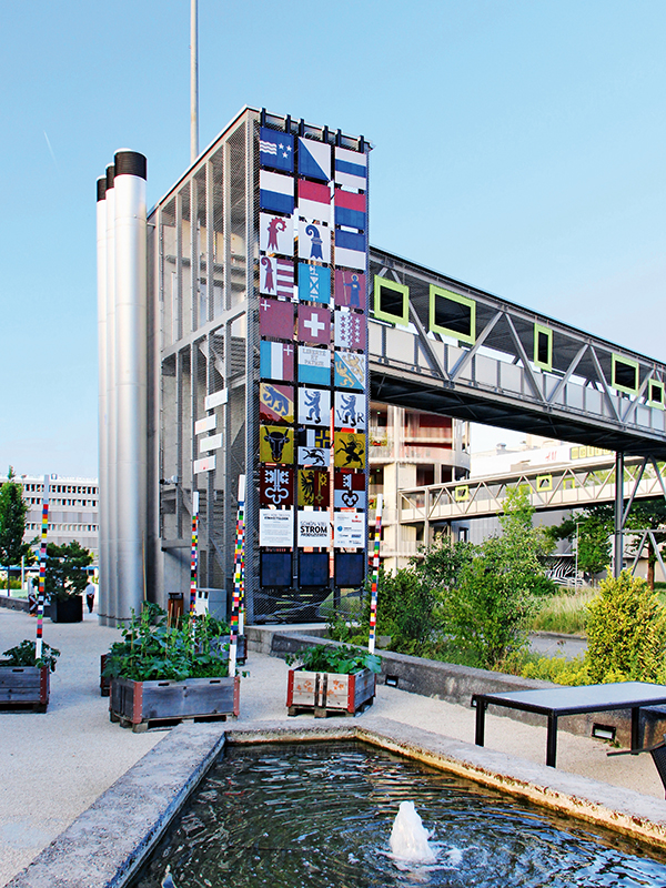 Die PV-Fassade «Swissness» besteht aus farbigen Modulen mit Motiven aller Schweizer Kantonsfahnen und der Bundesfahne. Sie demonstriert die Gestaltungsfreiheit von PV-Modulen mit digitalem Farbdruck. In der unteren Reihe sind baugleiche Module – ­allerdings ohne Farbdruck – montiert, die den visuellen und elektrischen Vergleich ermöglichen. Die Jahresproduktion dieser Module beträgt 840 kWh bei einer installierten Leistung von 1.59 kWp.