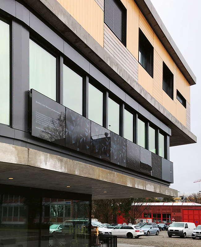 Die PV-Brüstung am Empa NEST: Die farbigen Elemente bestehen aus monokristallinen PV-Modulen (140 Wp/m2 aktive Fläche) auf schwarzer Folie und fast unsichtbaren, feinmaschigen Zellverbindern. Damit bilden sie einen annähernd homogenen Hintergrund für das Farbmotiv des Frontglases. Dieses hat drei verschiedene Ausführungen: strukturiert, glatt und satiniert (v.l.n.r.). Das gleiche Motiv wirkt auf den verschiedenen Glasoberflächen mit verschieden starker Reflexion jeweils ganz unterschiedlich.