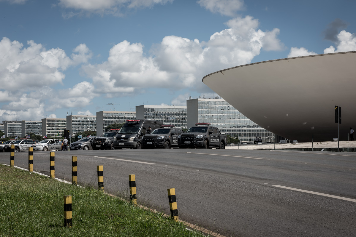 Alles gestaffelt: Ministerien, Polizeiautos, Strassenmarkierungen und Fahrbahnbegrenzer.