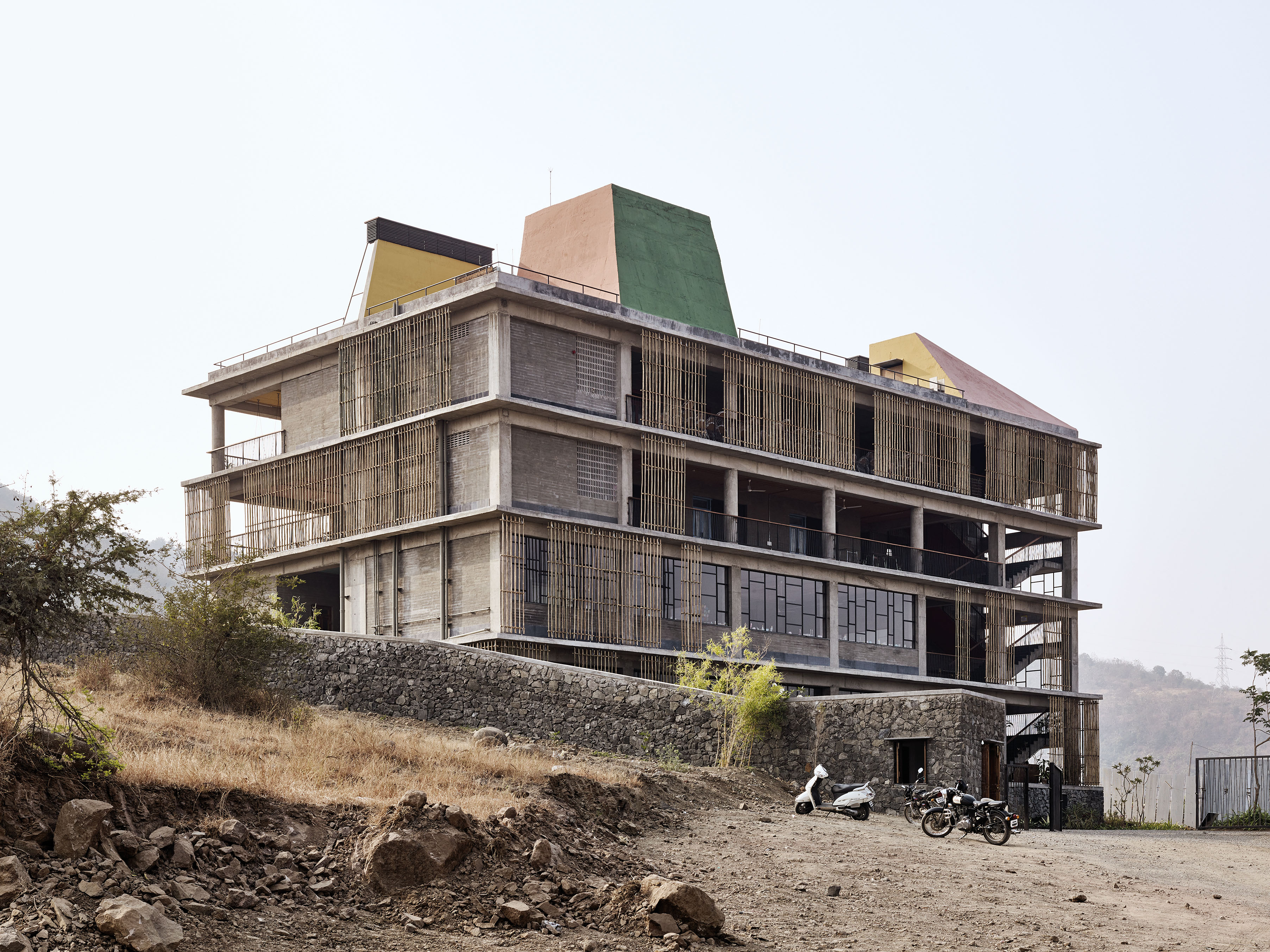 Tantôt ouverte, tantôt ombragée avec du bambou, la façade exprime la pluralité formelle du projet. Sur le toit, un dispositif d’évacuation de l’air chaud.