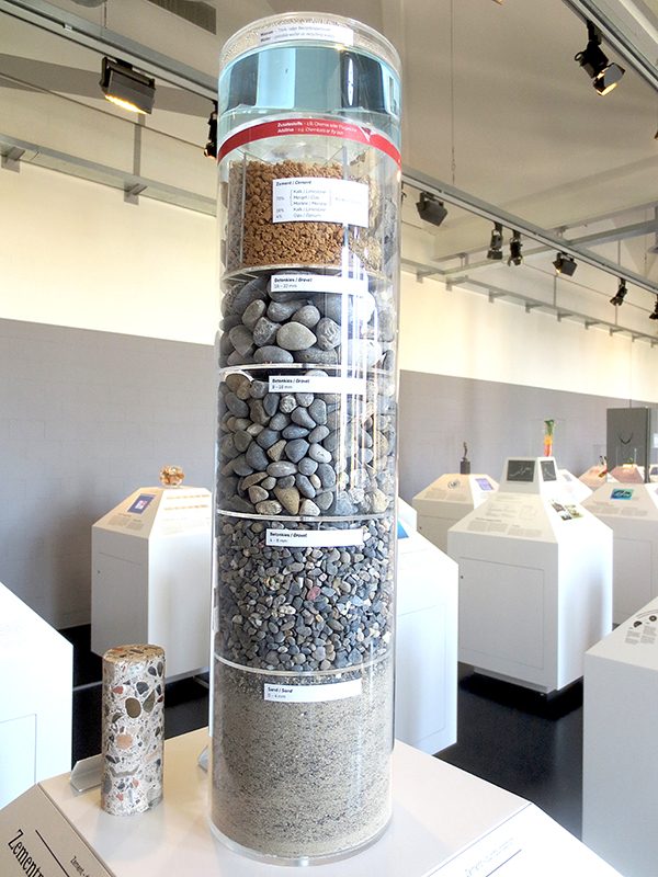 Zement: Der grosse Zylinder zeigt die Zusammensetzung von Beton. Neben Kies und Sand ist Zement ein wichtiger Bestandteil von Beton. Jedes Jahr werden mehr als 3.4 Mrd. t Zement produziert und verbaut.