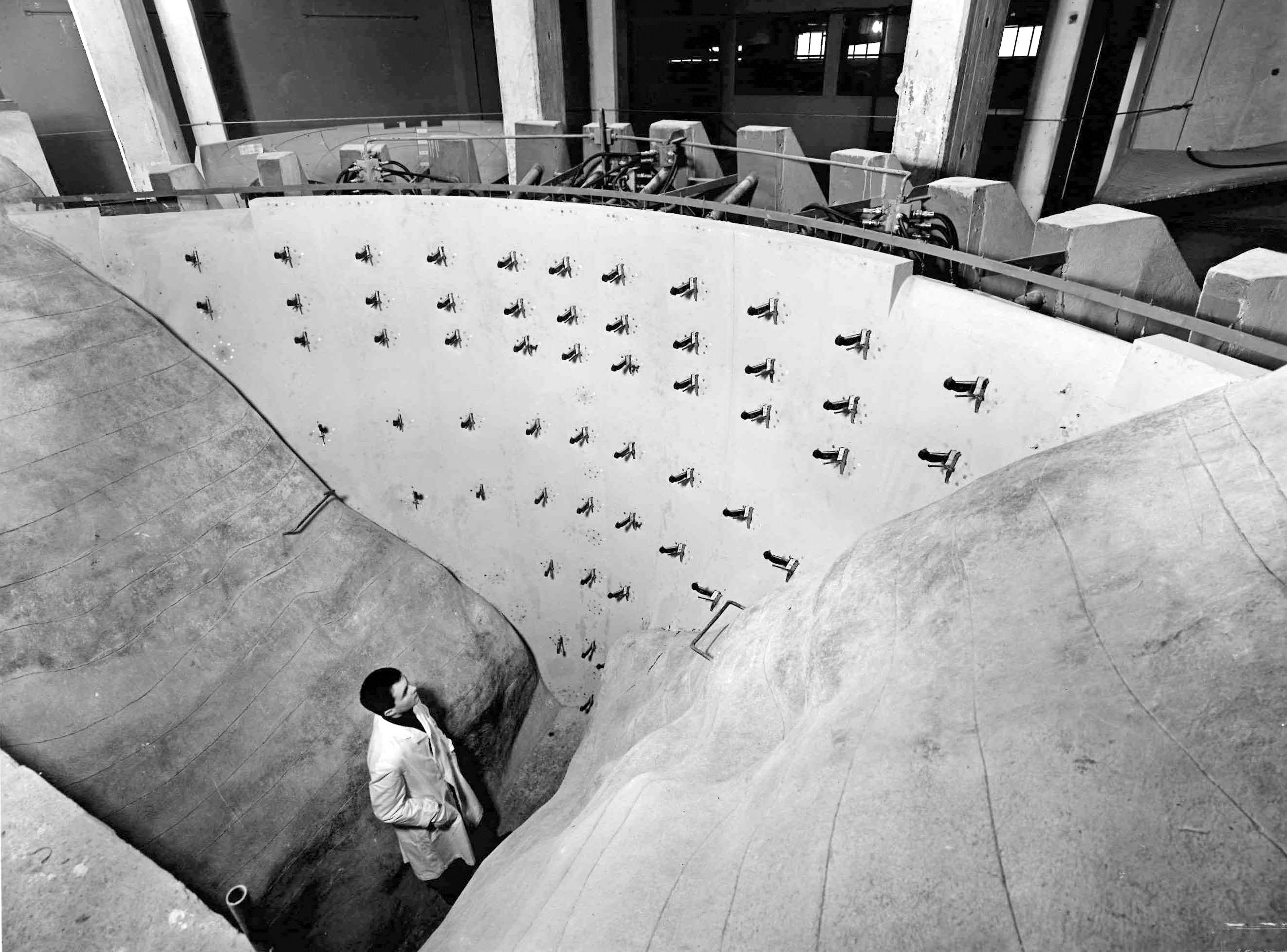 Le modèle du barrage-voûte de Contra, à l’échelle 1:66.6, avec, à l’arrière, les butées des presses hydrauliques simulant la sollicitation subie par la paroi du barrage