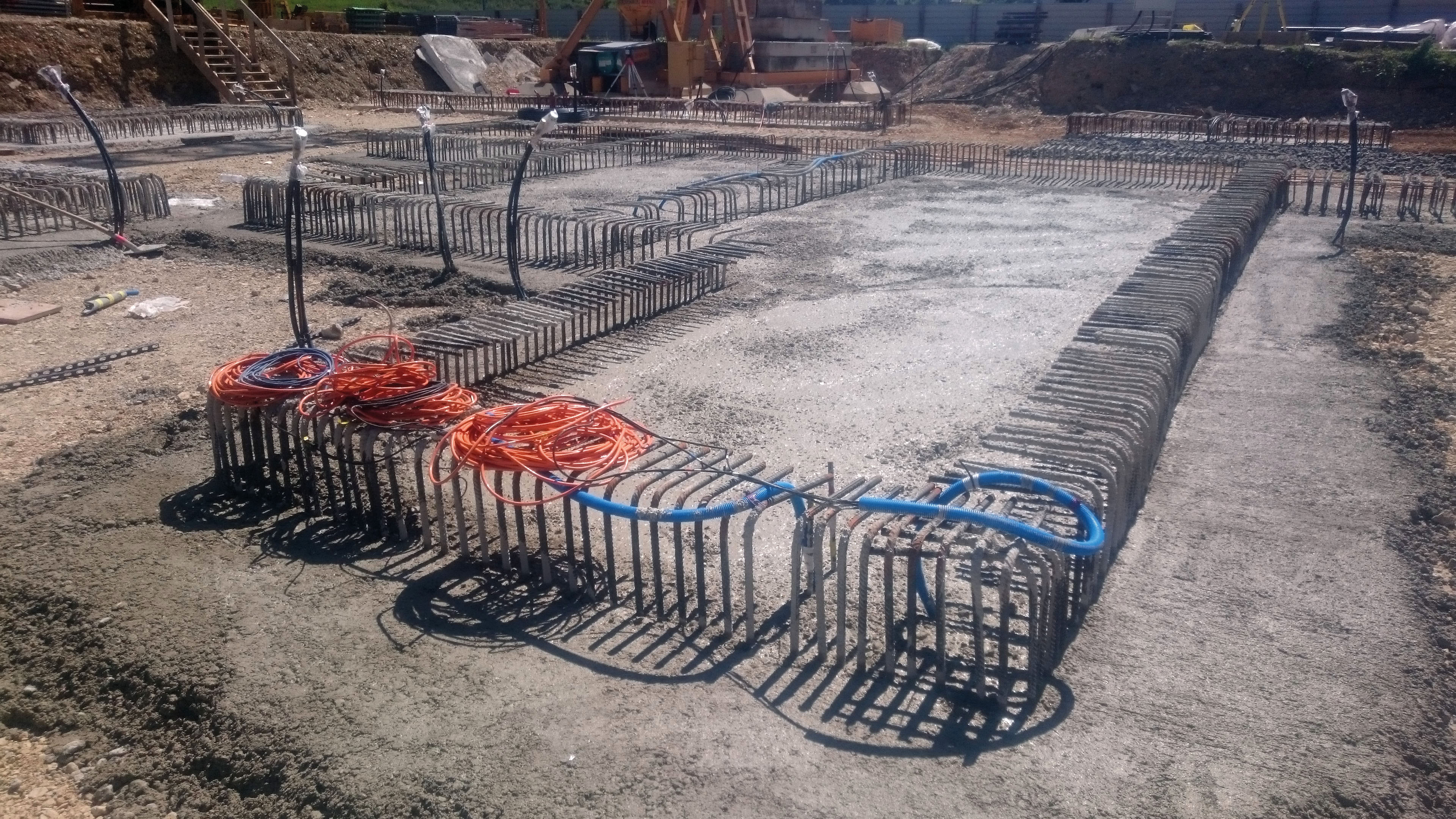 Bétonnage du radier ; les tubes énergétiques dépassent du sol d’une hauteur d’environ 2 m.