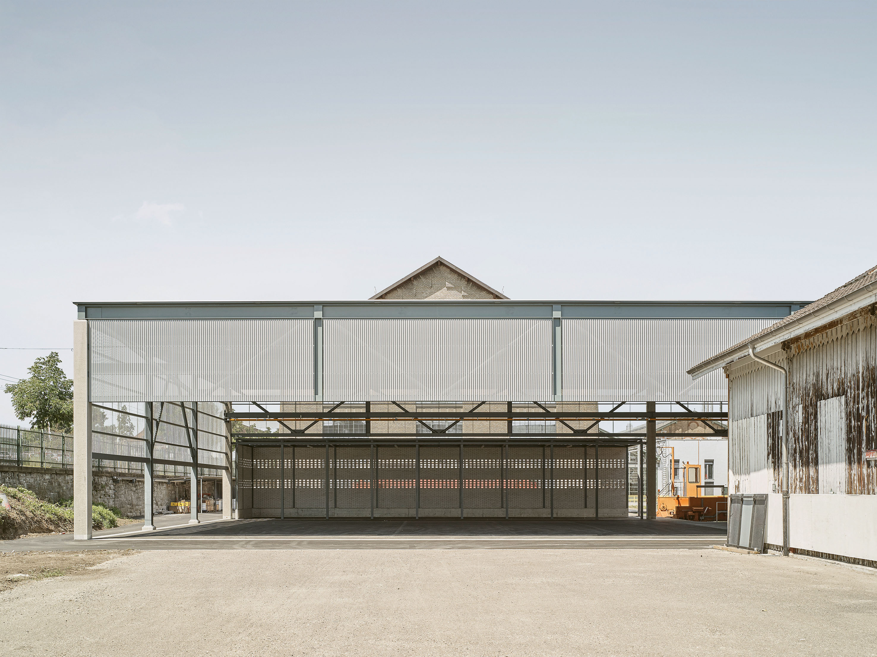 Entrepôt d’essieux, centre de réparation CFF, Zurich (mention) L’agence Brassel Architekten et le bureau des ingénieurs WaltGalmarini ont réalisé une halle destinée au stockage d’essieux et de conteneurs de matériaux recyclables entre des bâtiments industriels protégés au titre des monuments historiques. L’ossature métallique de la toiture repose sur six poteaux en béton coulé sur place empilés, répartis en poteaux primaires et secondaires. La structure de toiture se compose de poutre