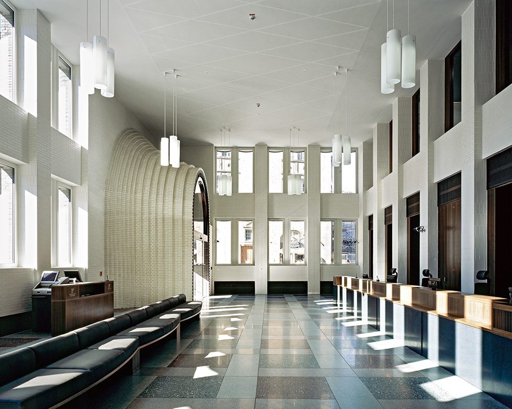 Aussen rot, innen weiss – dieses Gestaltungsprinzip der Bank zeigt sich exemplarisch am markanten Eingangsportal in die Schalterhalle.