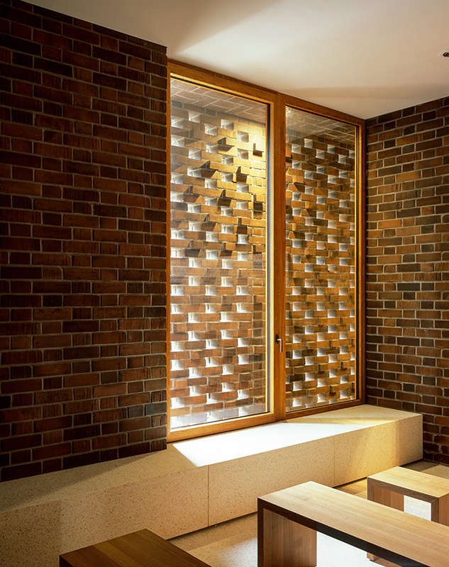 Das Lochmauerwerk im Andachtsraum filtert das Tageslicht und bietet Sichtschutz. Von hier aus kann der Kremation im Kultraum auch über ein Fenster beigewohnt werden.