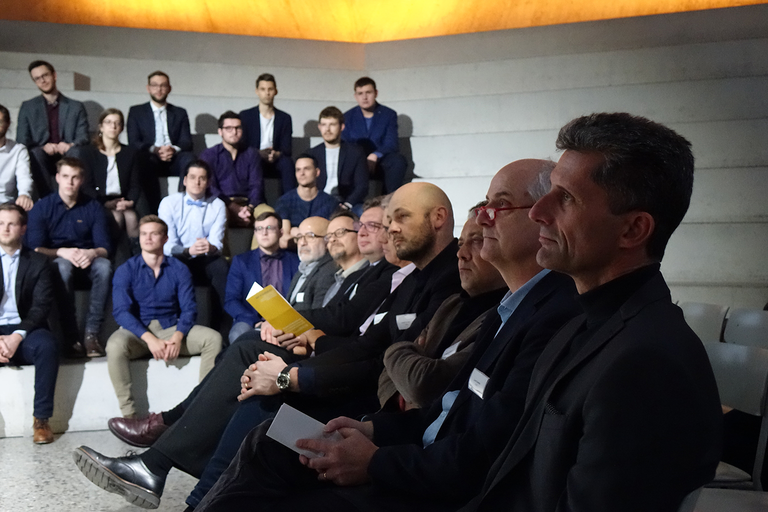 Die Studiengangsleiter Bauingenieurwesen der Schweizer Fachhochschulen, im Hintergrund die nominierten Studierenden.