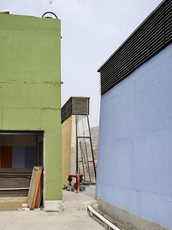 Dachlandschaft mit technischen Aufbauten. In der Bildmitte ist ein mit Sonnenwärme betriebener Abluftkollektor zu sehen.