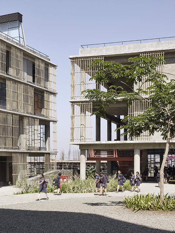 Die Bauten weisen tiefe Veranden auf, die mit Gittern aus zusammengebundenen Bambusstäben beschattet sind, wie sie in Indien für Baugerüste dienen, und dennoch genügend Tageslicht in die Räume lassen. Die gepflanzten Bäume werden wachsen und dem Aussenraum Schattenplätze und ein angenehmes Klima verleihen.