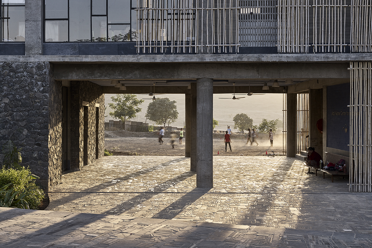 Blick in einen Hof und Hausdurchgang mit aus Abfalldeponien stammenden Steinen als Pflasterung. Der Architekt zeigte den Handwerkern Bilder vom Steinboden des Parthenons in Athen. Sie suchten die hier verwendeten Steine gemäss diesem Vorbild aus und verlegten sie entsprechend.