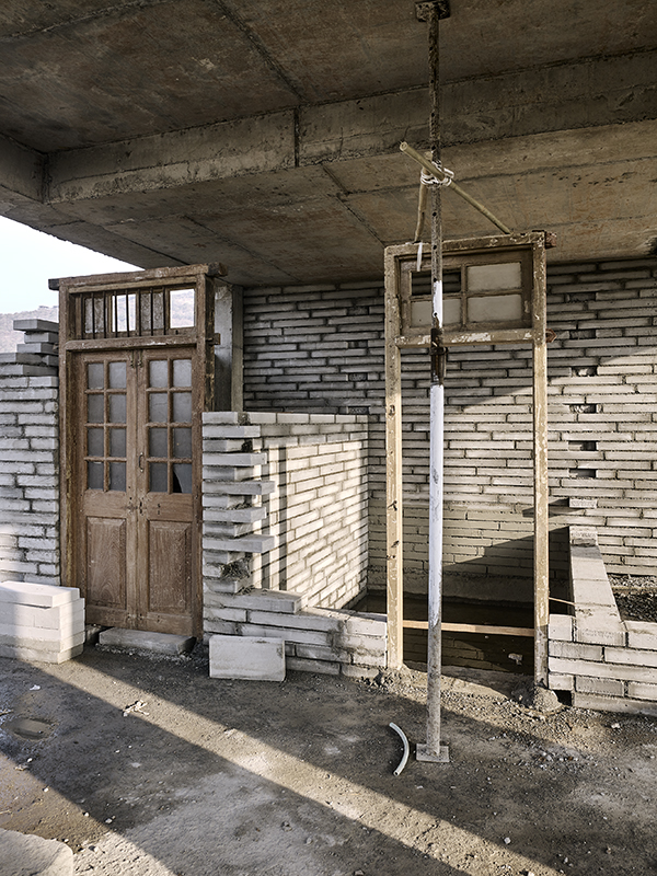 Die aus Abbruchhäusern in Mumbai rezyklierten Türen und Fenster werden aufbereitet und mitsamt ihren Rahmen an Ort und Stelle fixiert und eingemauert.