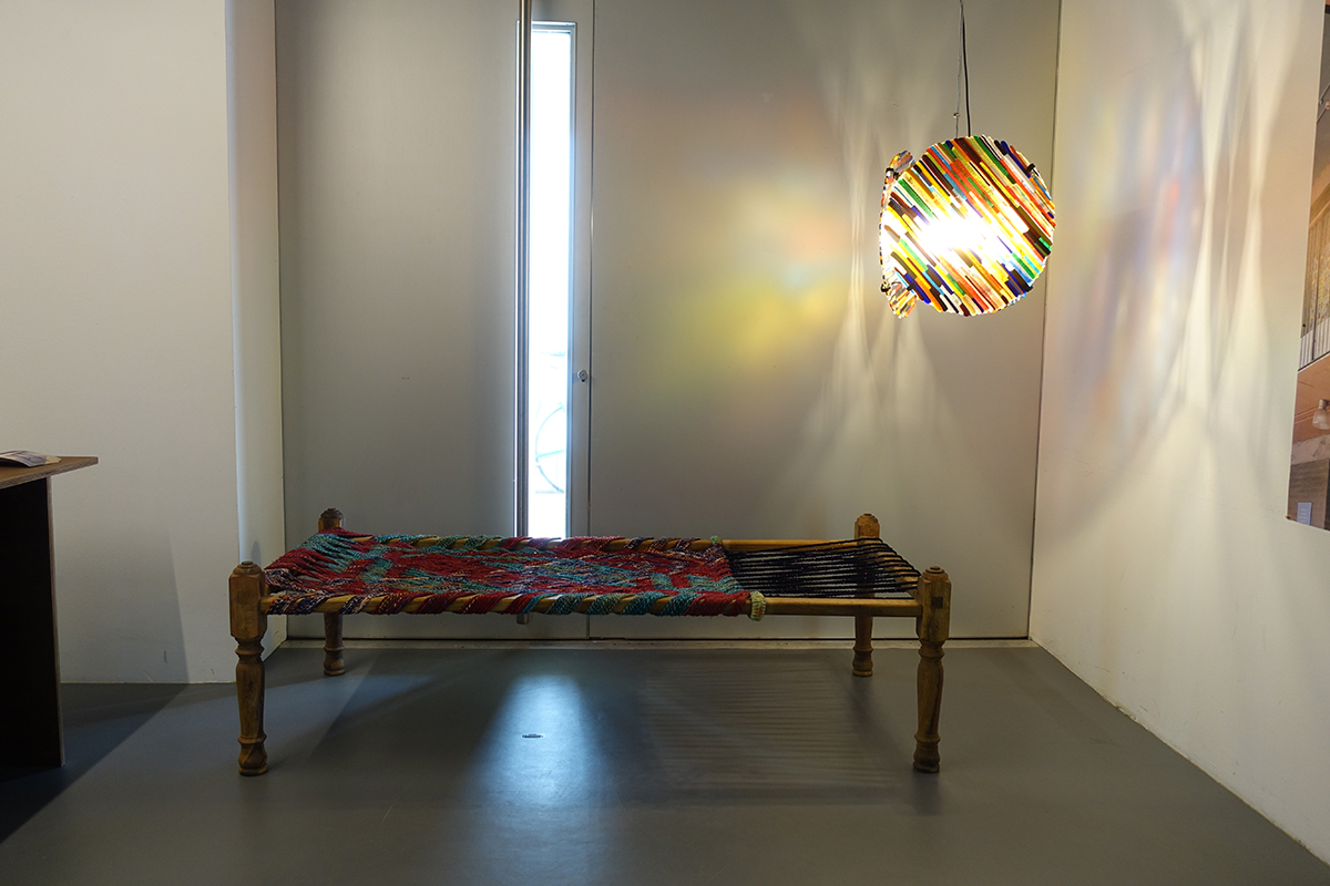 Eine geflochtene Sitzbank in der Ausstellung Archizoom. Die rechts sichtbare Schnurfläche dient dem Nachziehen der Verschnürung, wenn die Sitzfläche nach längerem Gebrauch durchzuhängen beginnt.