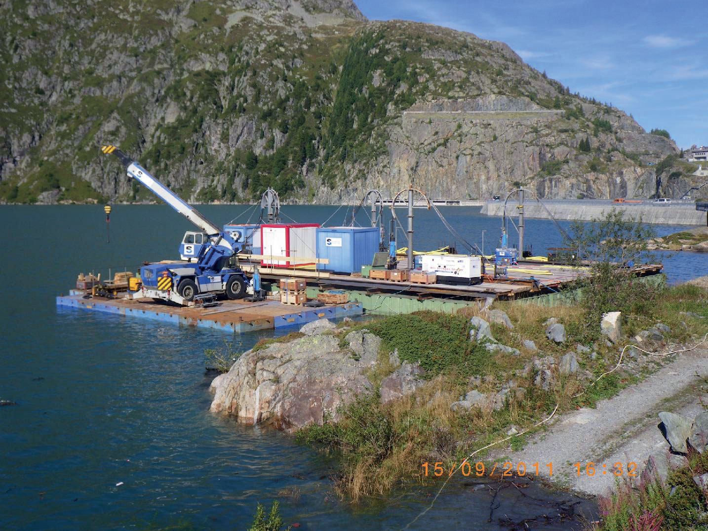 A droite, plateforme en pontons entièrement équipée. A gauche, plateforme secondaire avec une grue mobile pour le transbordement des équipements .