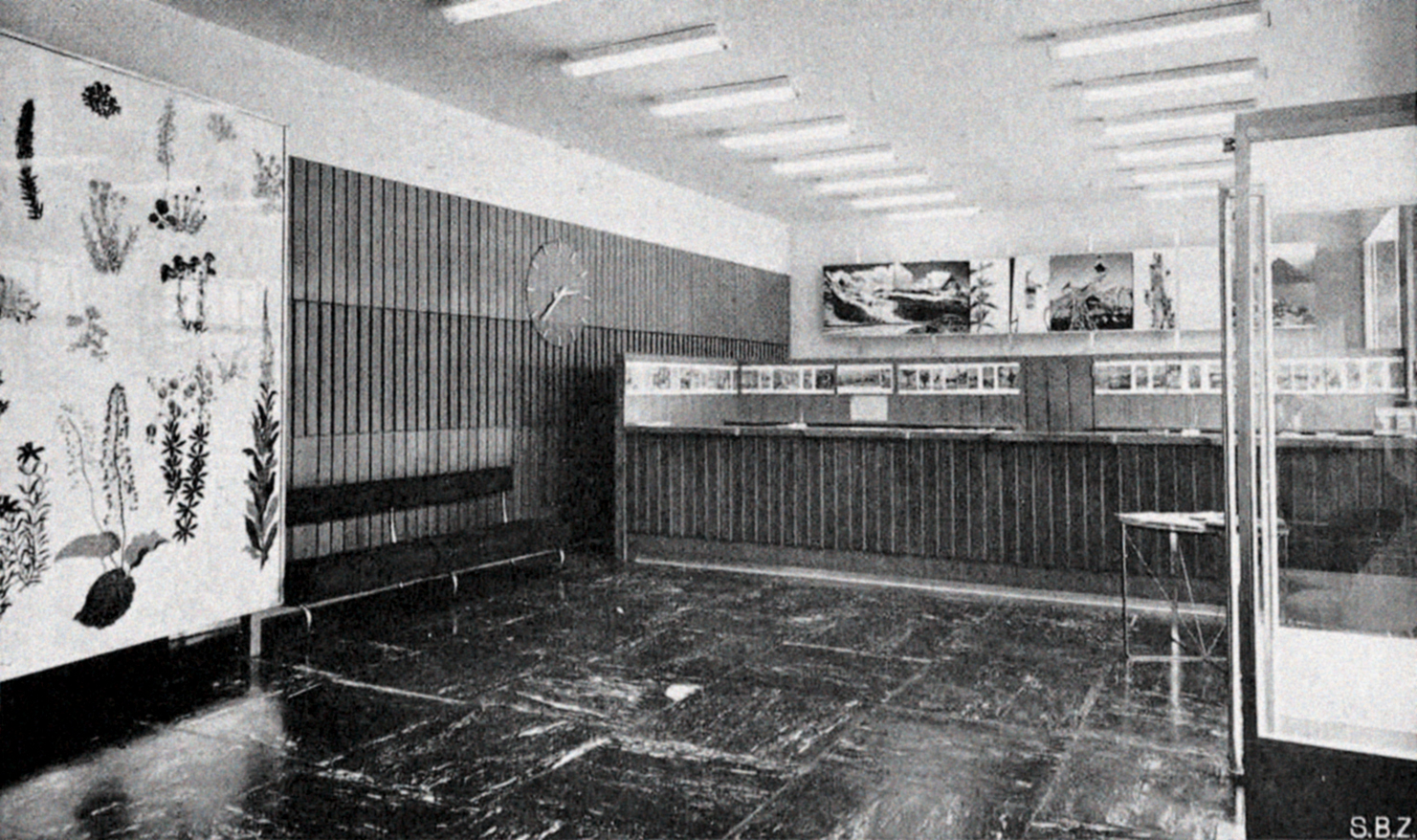Veduta della sala dell’ufficio turistico ubicato nel corpo basso, con in primo piano lo schermo in vetro dipinto di Noldi Soland. (Fonte: «Schweizerische Bauzeitung», n. 72, 1954)