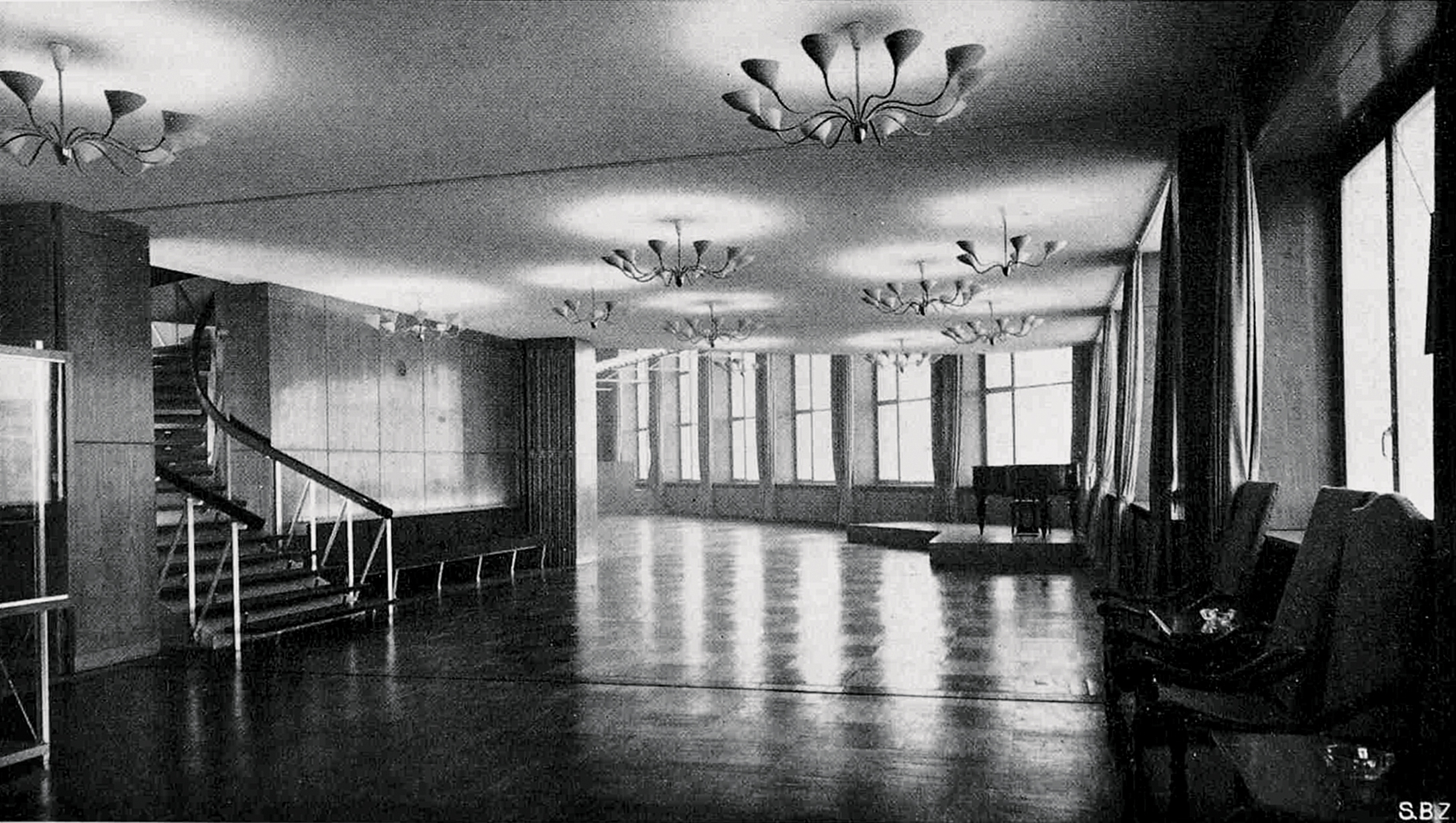 Veduta del foyer della sala delle feste, al terzo piano del corpo basso. Si notino i lampadari in vetro di Murano. (Fonte: «Schweizerische Bauzeitung», n. 72, 1954)
