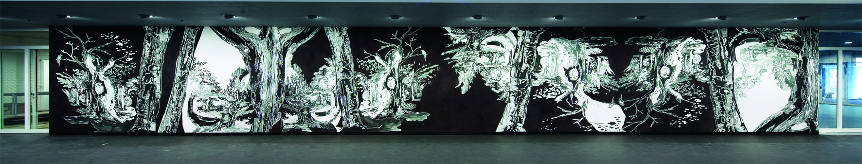 Künstlerische Intervention: Der Fries von Müller &amp; Müller, eine holzschnitt­artig wirkende Waldszenerie, in der sich an mehreren Stellen eine Eule verbirgt, erhebt sich über dem grau-braunen Polyurethan-Boden­belag