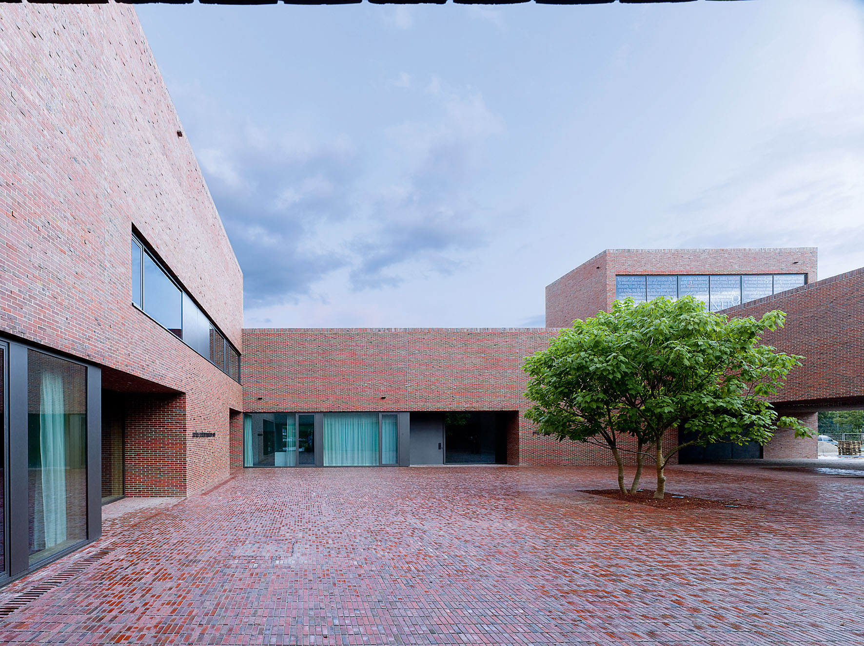 Dominikuszentrum in München, Blick in den Innenhof. Die vorgeblendete Fassade ist im Verband gemauert und vermittelt den Eindruck eines Massivbaus