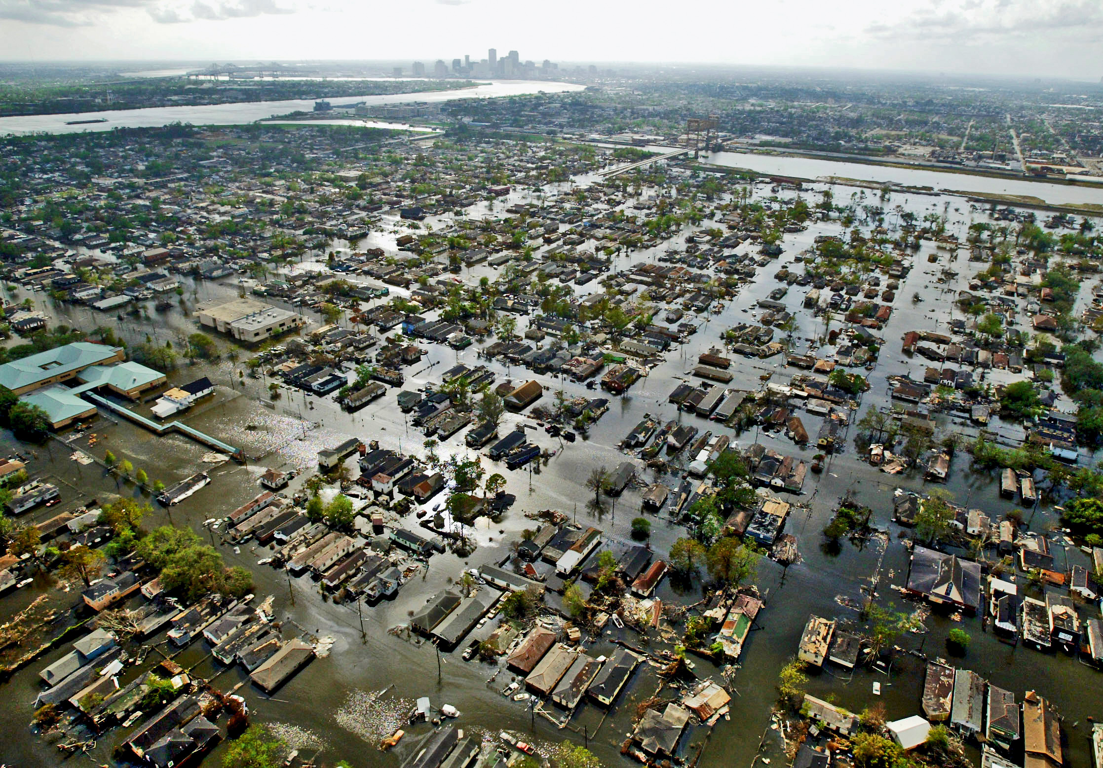 Das überflutete Lower Ninth Ward einige Tage nach Katrina, dahinter der Industriekanal, der in den Mississippi mündet, und das Stadtzentrum von New Orleans