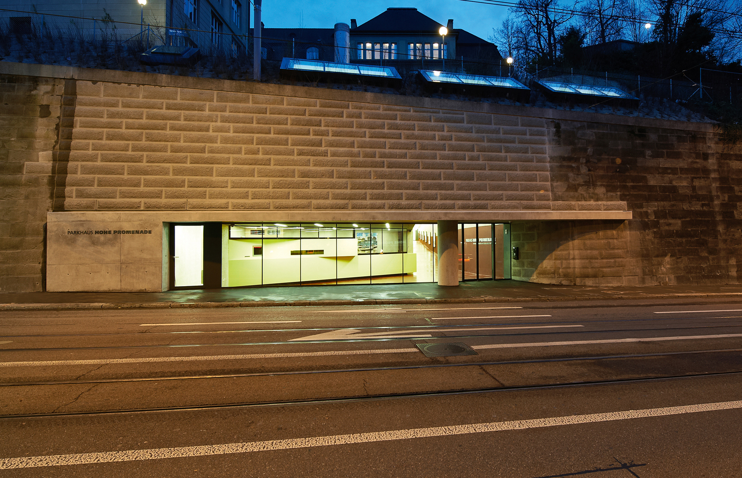 Der neu gestaltete Hauptzugang an der ­Rämistrasse: Der Fussgängerzugang zu den Parkebenen rechts von der Stütze ist über die gesamte Länge überblickbar. Die Loge für das Parkhauspersonal (links) erhält Tageslicht, das Werkstattgeschoss ist über Oblichter mit Licht durchflutet
