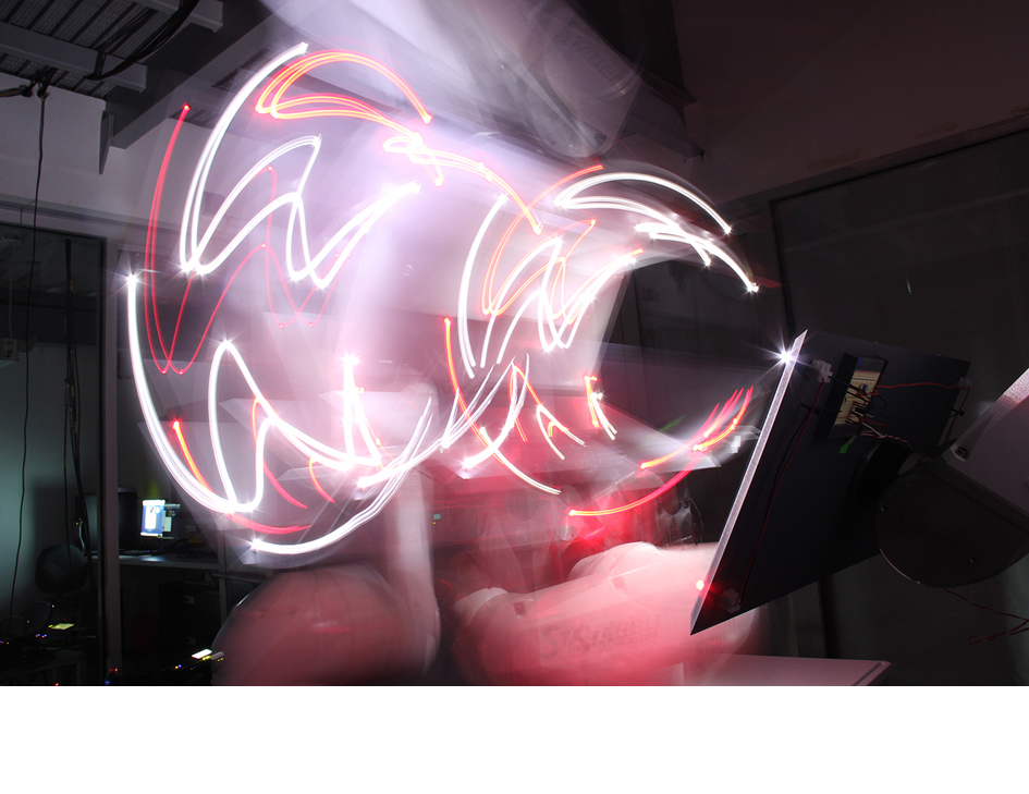 Eine Reihe von lang belichteten Fotos, aufgenommen aus jeweils unterschiedlichen Positionen, wurde zu einem Film zusammengehängt. Die resultierende Lichtzeichnung ist ein Abbild der Bewegungen des Roboterarms, der die Kamera hielt.