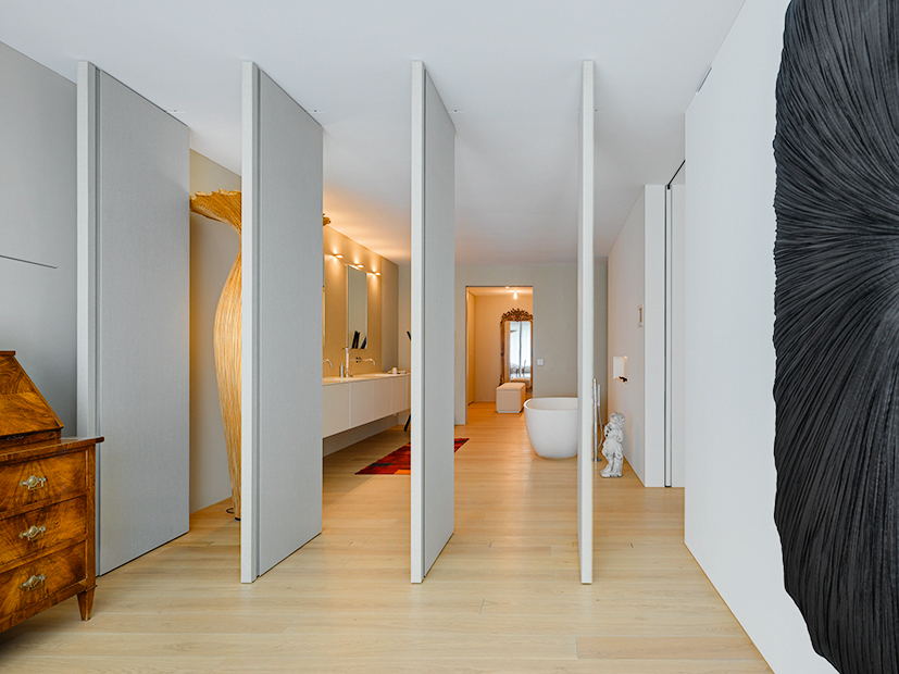 Um die Raumtiefe von 18m zu gliedern, setzte Daniel Lischer Drehelemente ein, die das Elternzimmer mit dem - ähnlich grossen - Badezimmer verbinden.