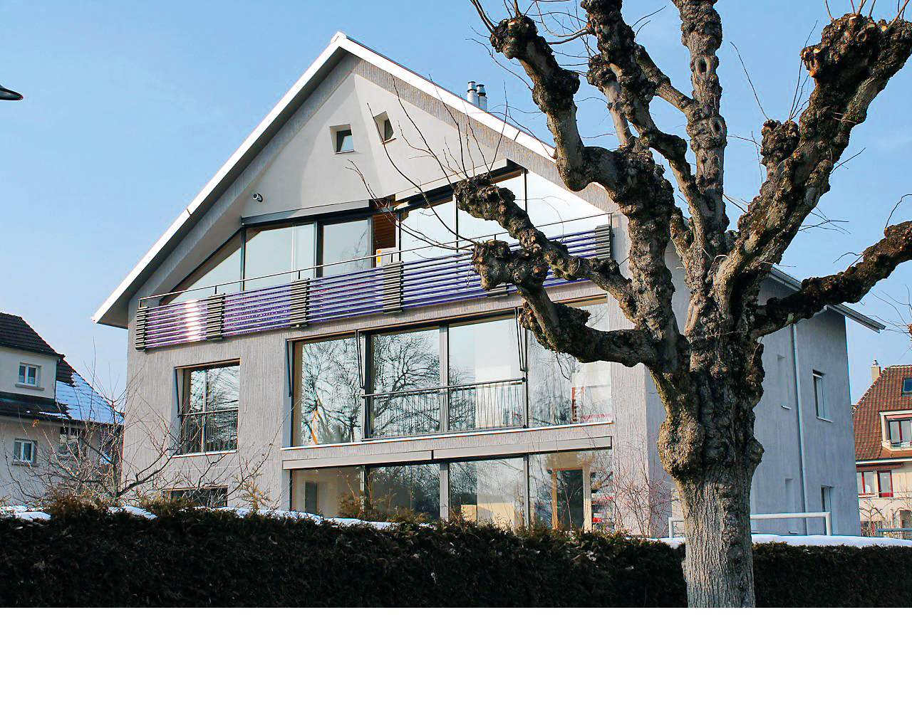 Mehrfamilienhaus in Thun: Der Low-Tech-Charakter des Umbaus äussert sich auch in der Fassade: Einzig die Balkonbrüstung mutet mit den Röhrenkollektoren ziemlich technoid an. Die Wände erscheinen mural, der eingeknickte Giebel lässt an ein riesiges Bündner