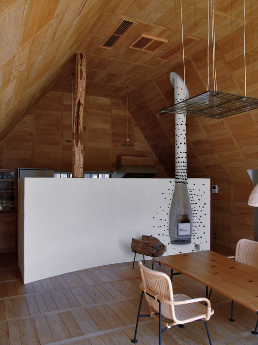 Die Fläche des Kamins im Yakisugi-Haus ist verputzt und mit Holzkohlestücken dekoriert. Die Stütze dahinter in der Küche stammt von einem Maulbeerbaum. (Foto: Terunobu Fujimori)