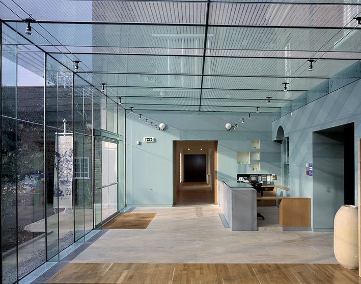 Glaspavillon der Ingenieure Dewhurst MacFarlane and Partners am Broadfield House in Kingswindford (GB, 1994). Er gilt bis heute als grösstes Glastragwerk, dessen Verbindungen nicht mit Profile und Schrauben ausgebildet wurden, sondern mit transparentem Gi