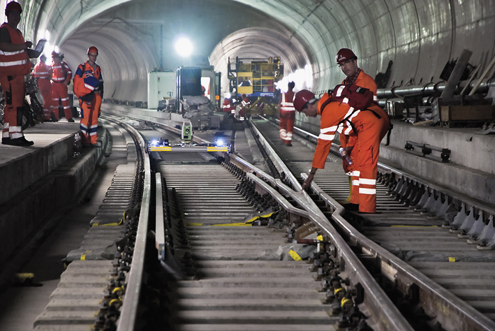 Kontrolle einer Weiche, im Hintergrund ein Gleiskontrollwagen. (Foto: AlpTransit AG)