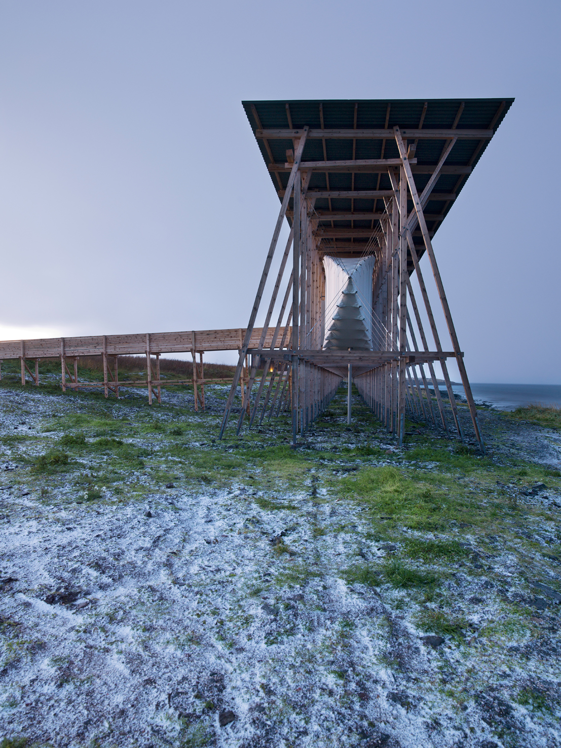 Der Holzbau ist parallel zum Ufer platziert, zwei Rampen führen ins Innere.