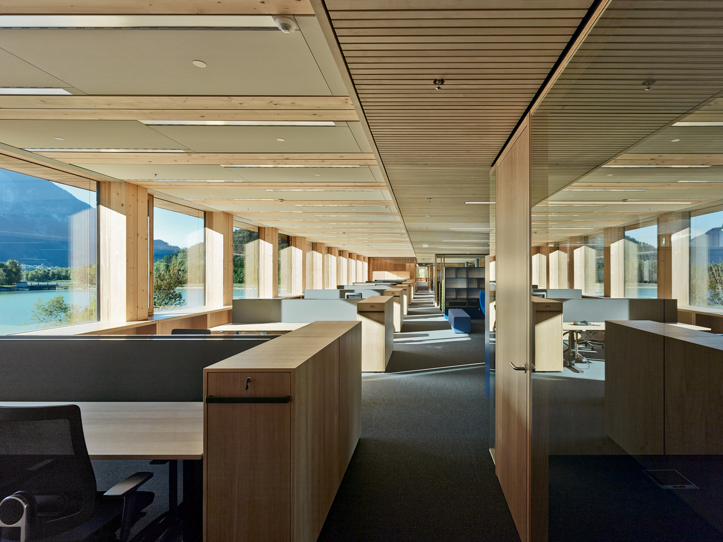 Aus dem Modul des Bausystems heraus entwickelt: Die Büroräume für die 270 Angestellten der Illwerke in Vandans bieten Aussicht in die Bergwelt des Montafons. Im Innern ist das Holz der Tragkonstruktion ohne Verkleidung zu sehen.