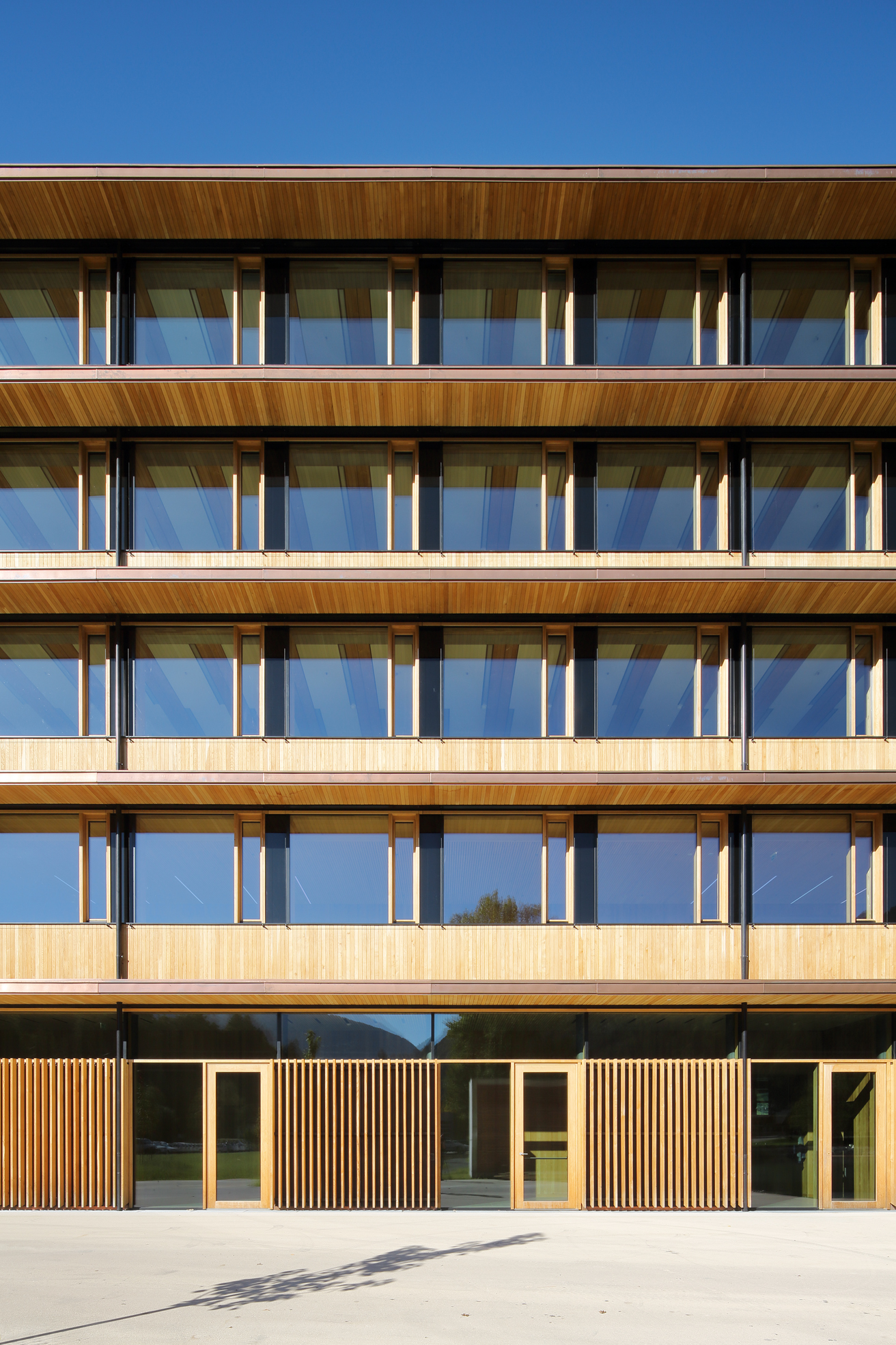 Auch die Fassade nimmt den Rhythmus der Konstruktion auf und zeigt eine strenge Gliederung, die die Länge betont. Dank sorgfältigen Details erscheint das Bürogebäude edel.