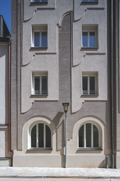 Bürogebäude Ismaninger Strasse, München, 2013: Das orna­mentale Relief verleiht der Fassade Tiefe, denn überdeutlich wird ein Schichtaufbau formuliert. Der glatte Silikonharz- Dekorputz wird von einer horizontal gerillten Kratzputzstruktur kontrastiert. Die Fassade ist durch die Komposition einfacher geometrischer Formen reich an Gestaltung. Sie scheint dem Gebäude ein massgeschneiderter Anzug aus feinem Stoff zu sein.