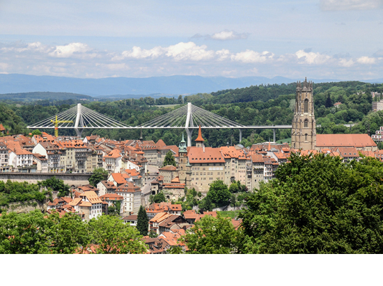 Stadt der Brücken: Freiburger Altstadt mit der Kathedrale St. Nikolaus (1283-1490), im Hintergrund die neue Poyabrücke. (Foto: Staat Freiburg/Eric Sauterel)