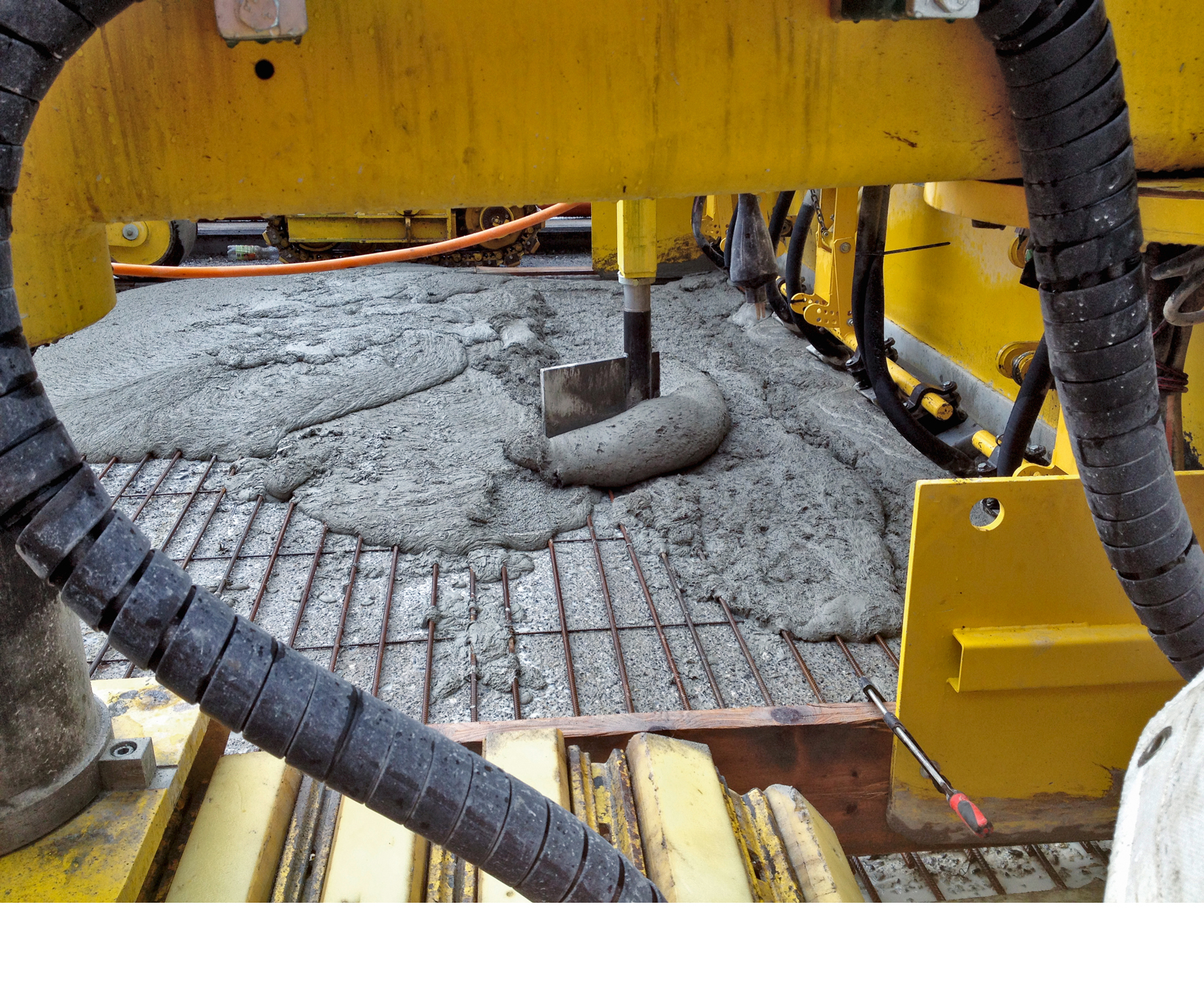 Eine Art Schaber verteilt den Frisch-UHFB, der mit leistungsstarken Vibratoren fertig eingebaut wird. (Foto: Jacques Perret)