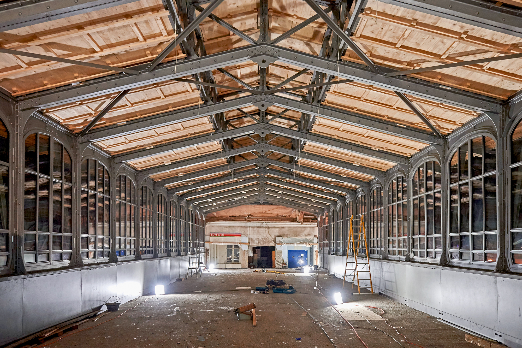 Das Tragwerk des Satteldachs mit dem im First aufgesetzten Oberlicht wurde nachträglich auf den Obergurt der Fachwerkträger gestellt. Es ist eine filigrane Stahlkonstruktion aus Zweigelenkrahmen. Windverbände steifen die Dachebene aus. (Foto: Jürg Zimmerm