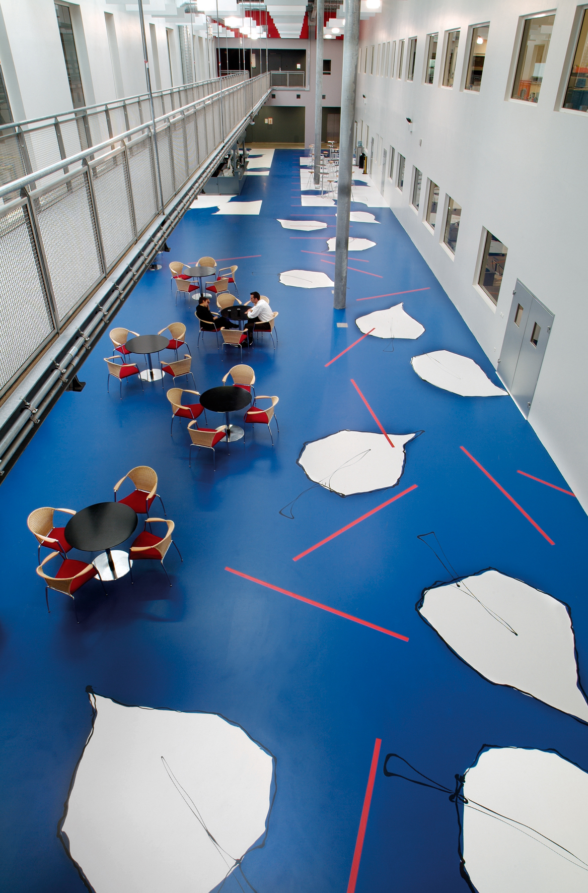 Im langgezogenen Atrium der Firma Danone in Paris dient die farbige Gestaltung des Bodens von Jeanet Hönig der Gliederung in einzelne Bereiche.