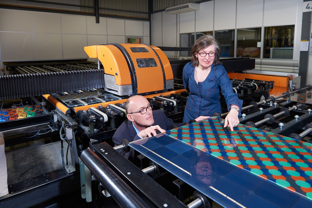 Monika Gold und Stephen Wittkopf von der Hochschule Luzern verfolgen den Druck eines Musters bei der Glas Trösch AG.