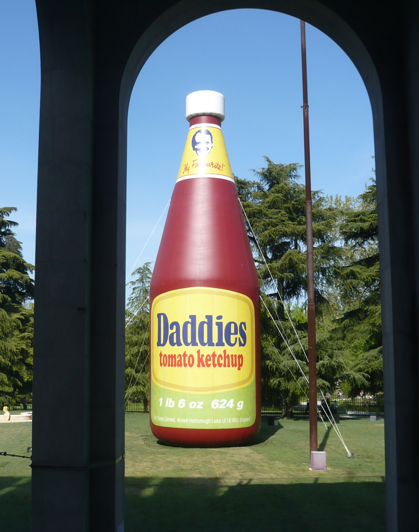 Im Garten steht eine riesige, von einem Gebläse aufrecht gehaltene Ketchup Flasche aus Plastik. Die Skulptur stammt vom US-amerikanischen Künstler Paul McCarthy (geb. 1945). Ein unübersehbares Signal, um das Gartencafe zu finden und sich von der umfangreichen Schau zu erholen.