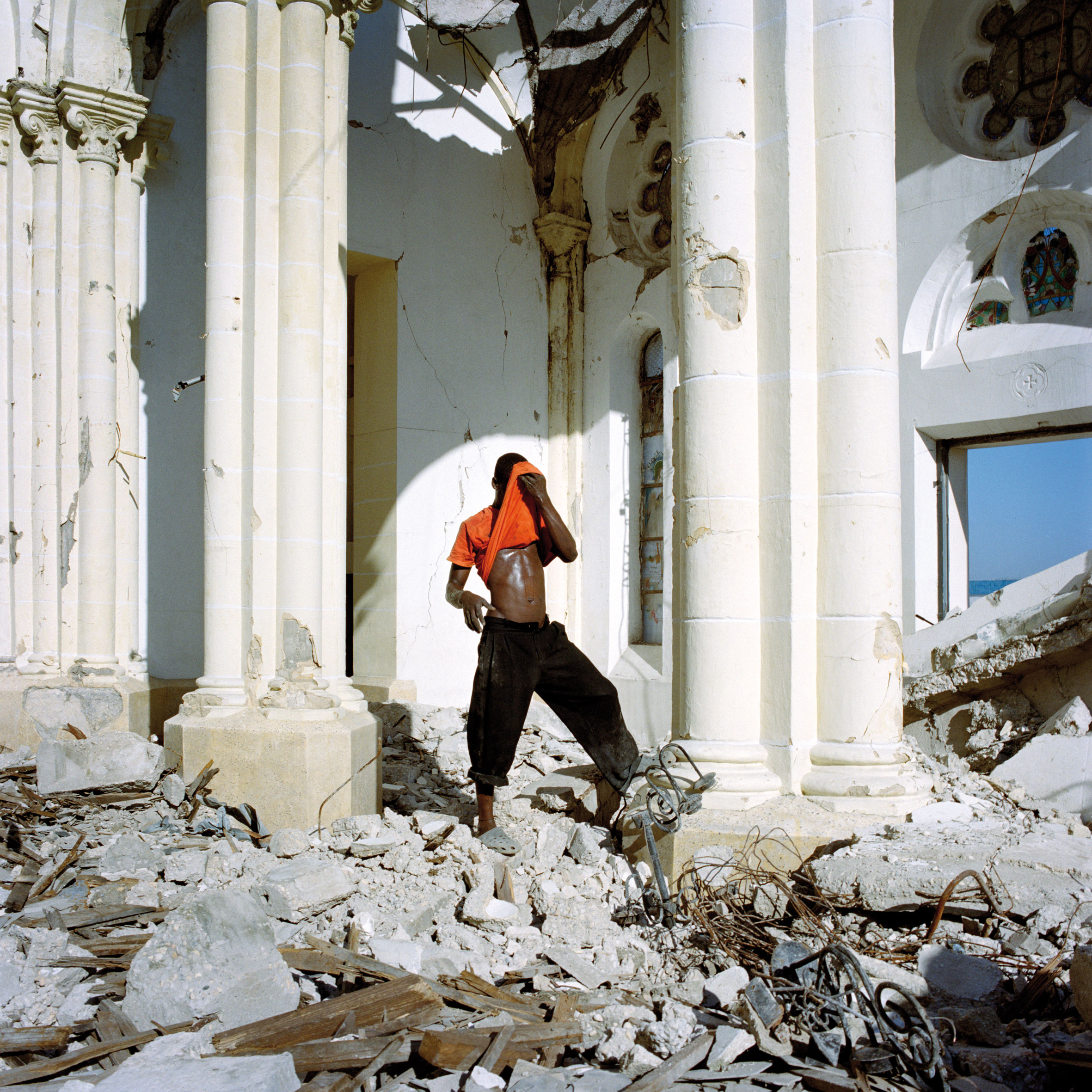 Intérieur de la cathédrale de Port-au-Prince. Dans les débris, les cantonniers récupèrent les structures de fer pour les revendre