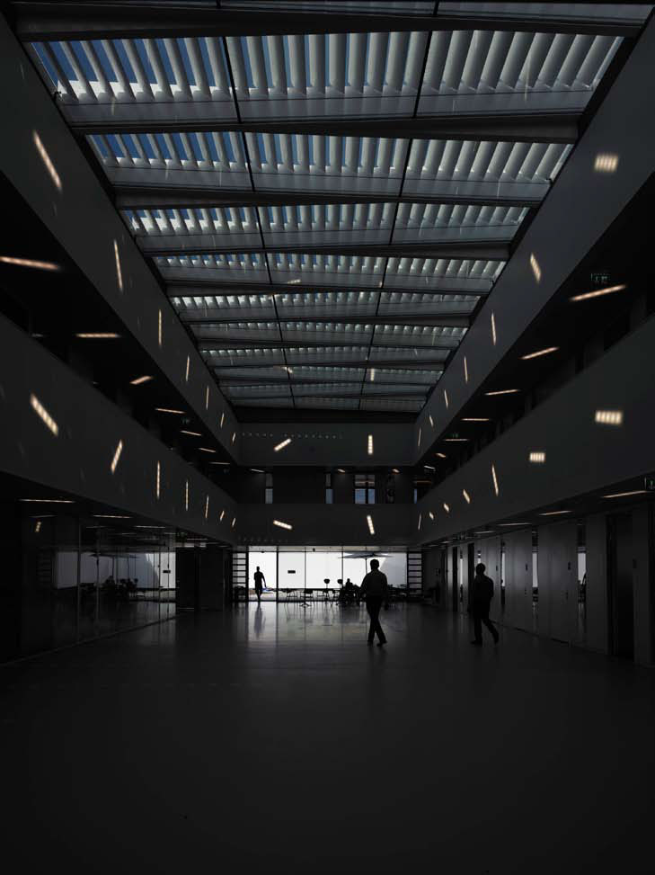 L’atrium à la tombée de la nuit. L’éclairage derrière les panneaux alvéolés est disposé de manière aléatoire.