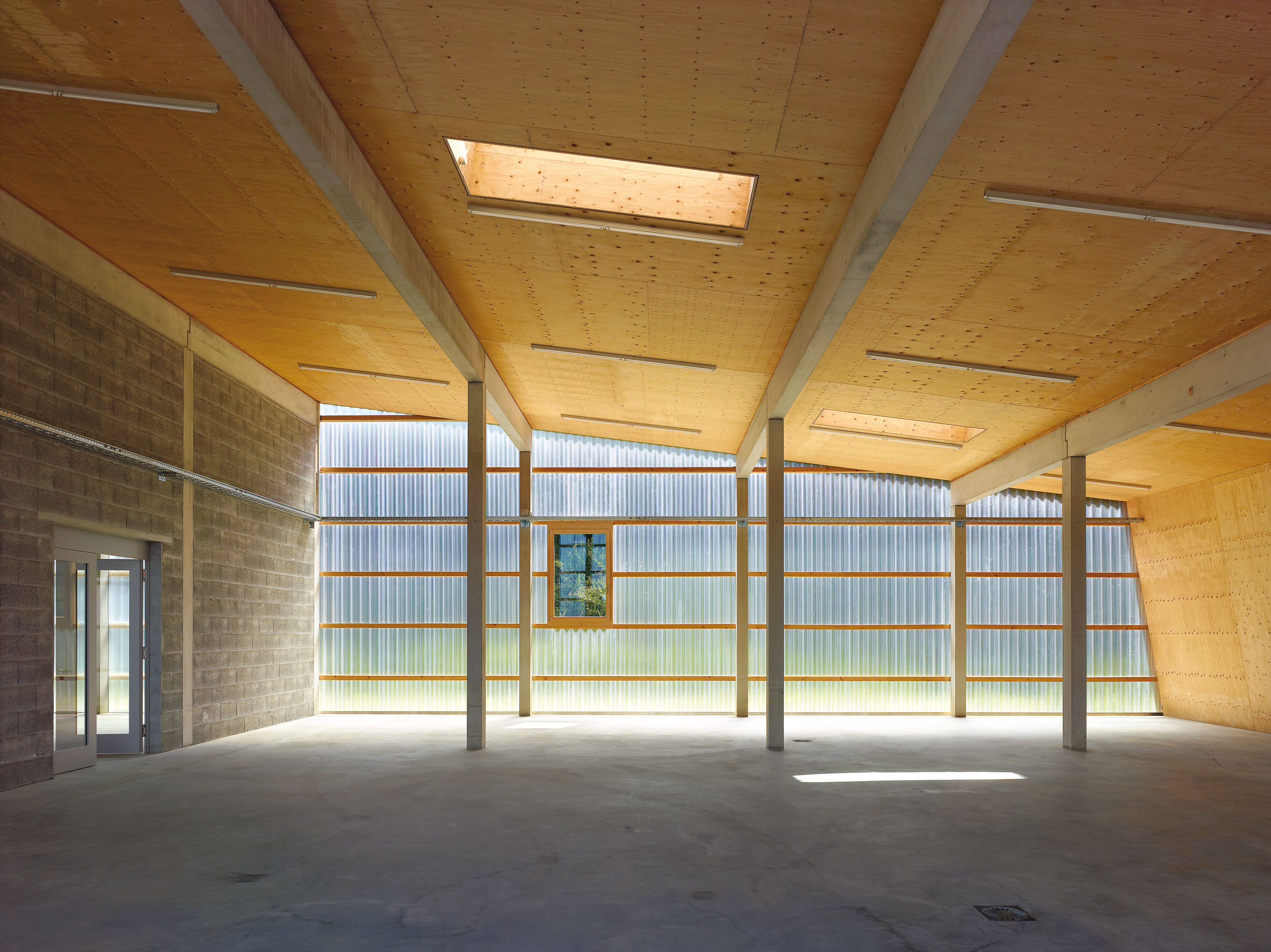 Une des halles du bâtiment des infrastructures de Gland, le polycarbonate en façade, les poteaux préfabriqués en béton et la «grande feuille» en bois