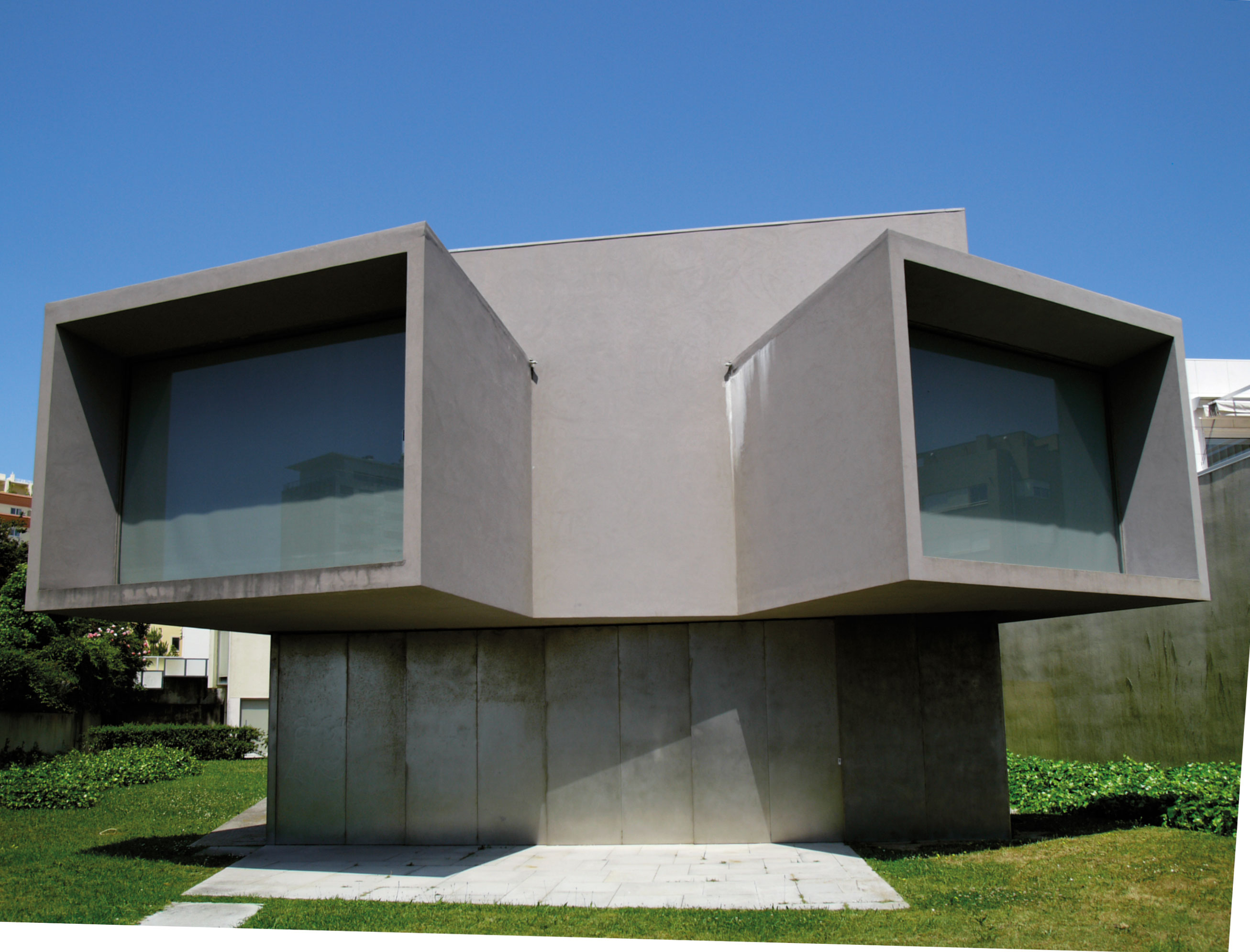 Casa do Cinema Manoel de Oliveira, Eduardo Souto de Moura, Porto: Petit bâtiment gris, affublé de deux ouvertures proéminentes qui ressemblent à des périscopes, noyé dans un environnement qui paraît presque hostile, où se dresse une douzaine de barres de dix étages en moyenne. L’édifice est dédié au réalisateur centenaire Manoel de Oliveira. Un petit gâchis, puisque la maisonnette n’a jamais servi. C’est l’une de ses réalisations que Souto de Moura aime le moins. «C’est un bâtimen
